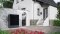 The image shows a heat pump outside a house
