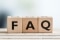 The picture shows three cubes with the letters F, A and Q, which stands for "Frequently Asked Questions".